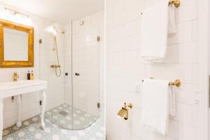 La salle de bains blanche est pourvue d'une douche et d'un lavabo. dans l'établissement Krusenberg Herrgård, à Krusenberg