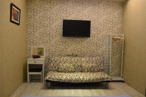 a living room with a couch and a television on a wall at Grapefruit Heping Guesthouse in Hualien City +28 photos