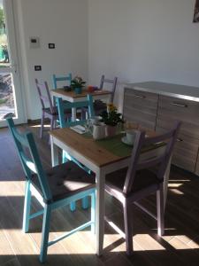 a dining room with two tables and blue chairs at B&B Le Farfalle in Onno +13 photos