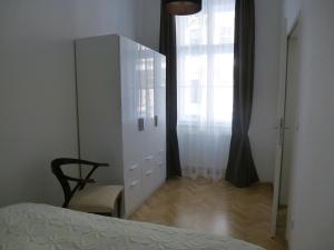 1 dormitorio con tocador blanco, silla y espejo en Charming Viennese Home en Viena