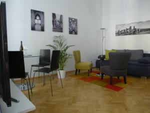 een woonkamer met een blauwe bank en stoelen bij Charming Viennese Home in Wenen