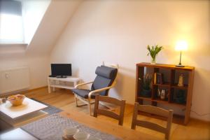 ein Wohnzimmer mit einem Stuhl und einem Schreibtisch in der Unterkunft Ferienwohnung Kirchturmblick Euren in Trier