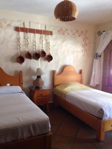 1 dormitorio con 2 camas, ollas y sartenes en la pared en Hotel El Portón en Tenancingo de Degollado