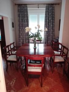 a dining room table with a vase of flowers on it at Precioso Piso junto a Plaza de España in Seville