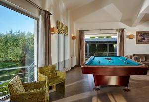 una mesa de billar en una habitación con una ventana grande en Villa EverGreen en Foinikiá