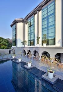 un hôtel avec une piscine et un bâtiment dans l'établissement Radisson Blu Atria Bengaluru, à Bangalore