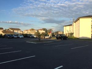 an empty parking lot with cars parked in it at Hôtel Gardenia Bordeaux Est in Yvrac