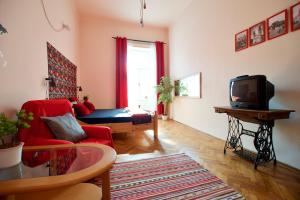 ブダペストにあるBudget Apartment by Hi5 - Üllői 36のリビングルーム(赤いソファ、テレビ付)