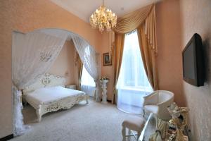 una camera con letto bianco e lampadario pendente di Oreanda Hotel a Odessa