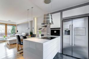 a kitchen with a stainless steel refrigerator and a living room at Orlowska43 in Gdynia