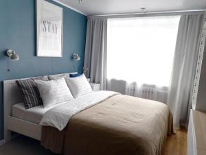ペトロパブロフスク・カムチャツキーにあるApartment Perfect Homeのベッドルーム1室(青い壁のベッド1台、窓付)