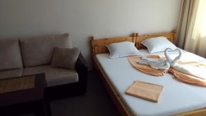 a bedroom with a bed with a chair and swan towels at Guest House Diamant in Sozopol