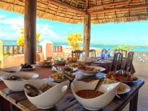 una mesa con tazones y platos de comida. en Msafini Hotel, en Lamu