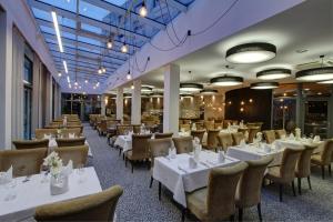 a dining room with white tables and chairs at Haston City Hotel in Wrocław