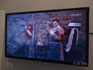 a television screen with a picture of a man holding a baseball bat at Willa Centrum in Krynica Zdrój