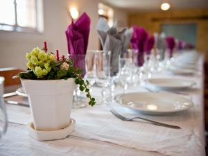 stół z doniczką na białej tkaninie stołowej w obiekcie Logis Hotel Restaurant Le Relais Fleuri w mieście Vervins