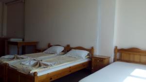 two twin beds in a room with two tables at Guest House Diamant in Sozopol