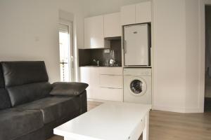 a living room with a couch and a washing machine at Apartamentos San Agustín in Murcia