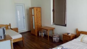 a bedroom with two beds and a table and a door at Guest House Diamant in Sozopol