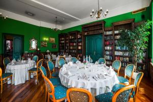 uma sala de jantar com mesas e cadeiras e paredes verdes em Shakespeare Boutique Hotel em Vilnius