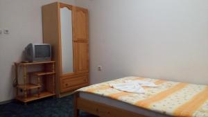a bedroom with a bed and a small tv at Guest House Diamant in Sozopol