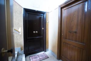 a black door in a hallway next to a wooden door at Quo Vadis in Rome