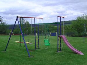 - une aire de jeux avec des toboggans et des balançoires dans un parc dans l'établissement Chambre d'hotes de la Mousse, à Saint Remy sur Orne