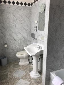 uma casa de banho com um lavatório branco e um WC. em Europäischer Hof am Dom em Colônia