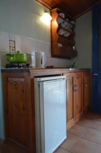 a kitchen with wooden cabinets and a white refrigerator at "STELIOS & GALINI" in Symi