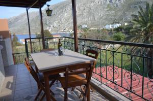 a table with a bottle of wine on a balcony at "STELIOS & GALINI" in Symi