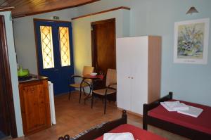 a room with a bed and a kitchen with a table at "STELIOS & GALINI" in Symi
