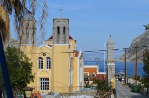 a yellow church with a cross on top of it at "STELIOS & GALINI" in Symi