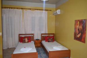 two twin beds in a room with a window at "STELIOS & GALINI" in Symi