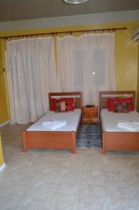 two beds sitting in a room with curtains at "STELIOS & GALINI" in Symi