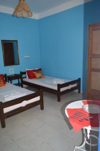 a room with two beds and a blue wall at "STELIOS & GALINI" in Symi