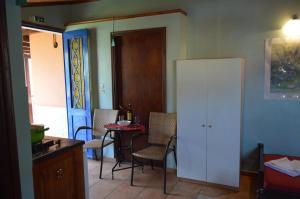 a kitchen with a table and chairs and a white refrigerator at "STELIOS & GALINI" in Symi