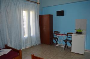 a room with a kitchen and a table with a window at "STELIOS & GALINI" in Symi
