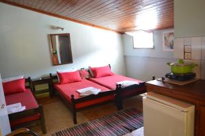 a living room with a red couch and a mirror at "STELIOS & GALINI" in Symi