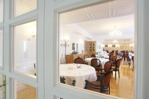 un comedor con mesas y sillas y una ventana en Tesoretto Hotel, en Poggiardo