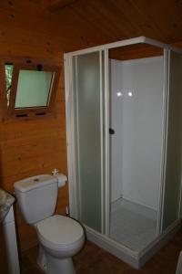 a bathroom with a toilet and a glass shower at Bungalows y Glamping Medina Sidonia in Medina Sidonia