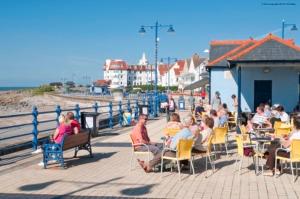 un grupo de personas sentadas en sillas en un muelle en Esplanade Seaside View Apartment, en Porthcawl