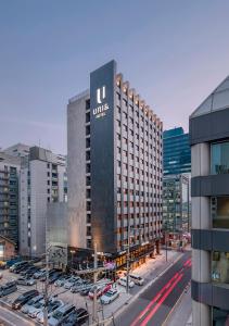 un grand bâtiment avec un panneau dans un parking dans l'établissement Hotel Uri&, à Séoul