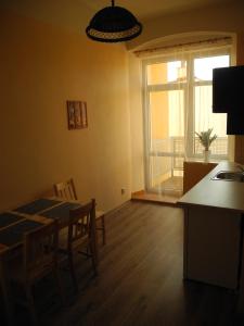 ein Wohnzimmer mit einem Tisch, einem Fenster, einem Tisch und Stühlen in der Unterkunft Apartmá Anglická in Franzensbad