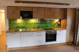 a kitchen with white cabinets and a sink at Ferienhof Bernegglehen in Berchtesgaden