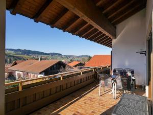 a balcony with chairs and a view of a house at Ferienwohnungen Wörner in Oberstaufen