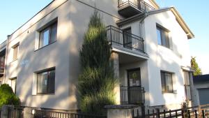 a white building with a tree in front of it at Penzion Olomouc in Olomouc