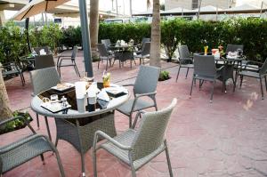 an outdoor patio with tables and chairs and tables and chairs at Dammam Palace Hotel in Dammam