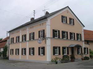 ein großes weißes Gebäude mit schwarzen Fenstern auf einer Straße in der Unterkunft Gasthof Post in Großaitingen