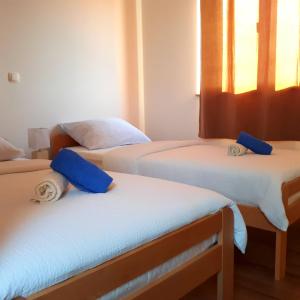 um quarto com 3 camas com almofadas azuis em Apartment Tea em Nin