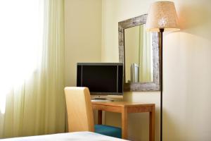 a bedroom with a desk with a television and a mirror at Pestana Viking Beach & SPA Resort in Armação de Pêra
